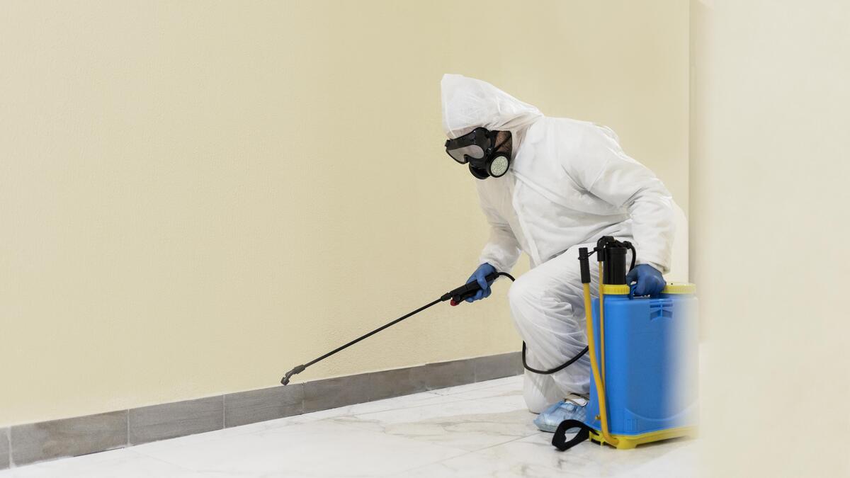 Full Shot Man Disinfecting Wall (1)